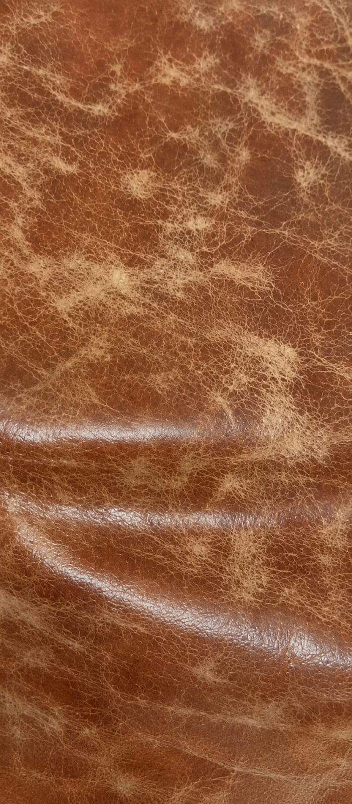 Materiales de cuero en tonos cálidos, con textura y pliegues naturales